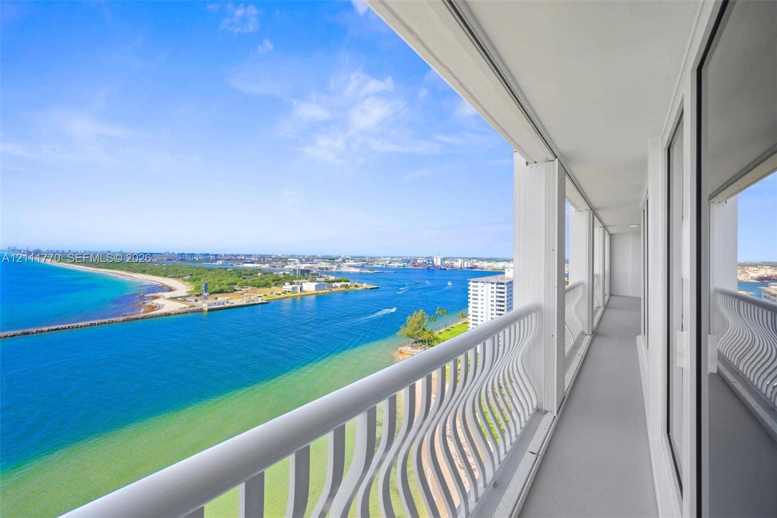 2200 S Ocean Lane, #2204, Fort Lauderdale, FL 33316 High-rise balcony featuring a white metal serpentine railing, neutral flooring, and expansive water frontage