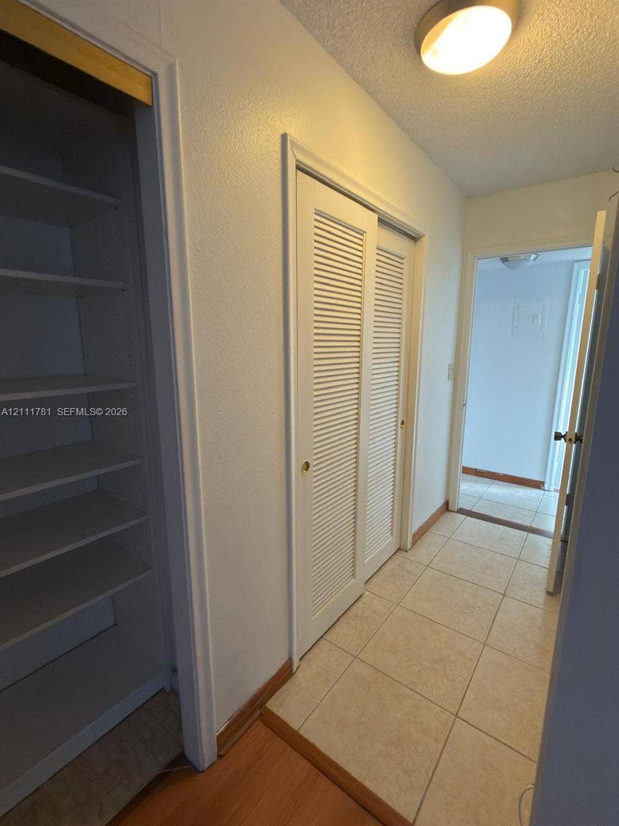 900 NE 12th Avenue, #401, Hallandale Beach, Hallandale Beach, FL 33009 Built-in shelving units, dual louvered closet doors, and ceramic tile flooring