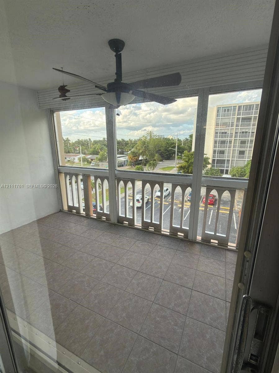 900 NE 12th Avenue, #401, Hallandale Beach, Hallandale Beach, FL 33009 Enclosed balcony featuring tile flooring, decorative arched railings, and a ceiling fan
