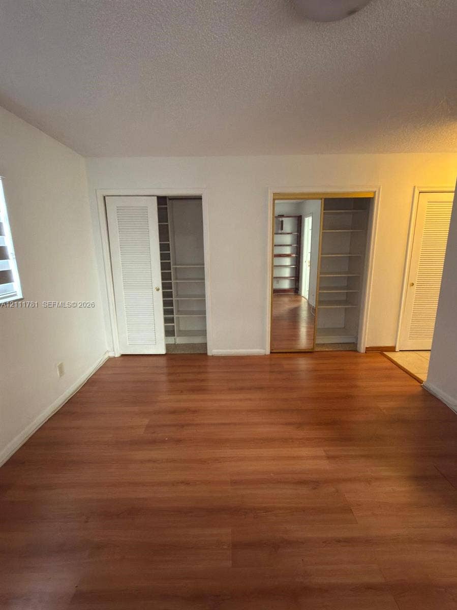 900 NE 12th Avenue, #401, Hallandale Beach, Hallandale Beach, FL 33009 Wood-finish flooring, louvered-style closet doors, and built-in shelving units
