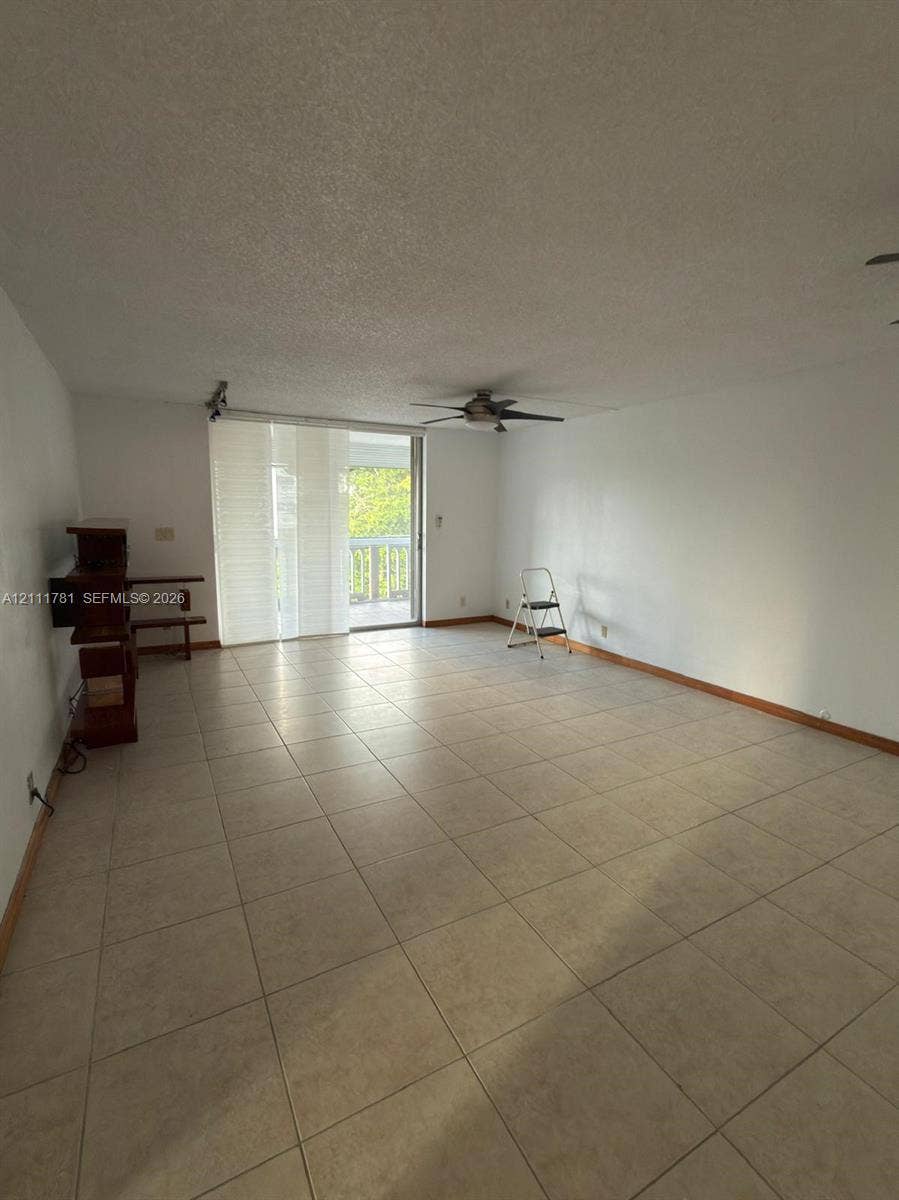 900 NE 12th Avenue, #401, Hallandale Beach, Hallandale Beach, FL 33009 Neutral-toned tile flooring, ceiling fan, and sliding glass door leading to an outdoor balcony