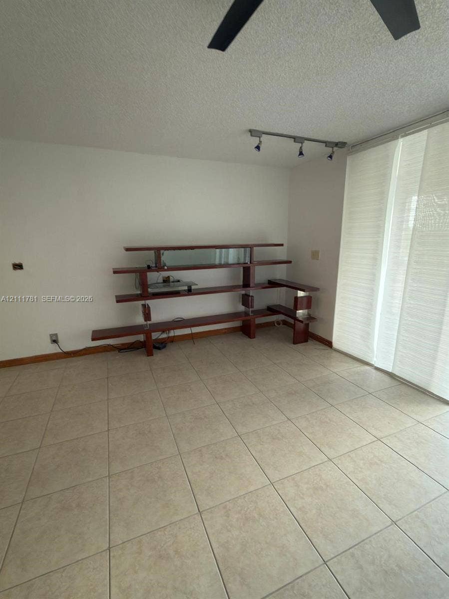 900 NE 12th Avenue, #401, Hallandale Beach, Hallandale Beach, FL 33009 Neutral tile flooring, built-in multi-level shelving unit with wood finish, and track lighting