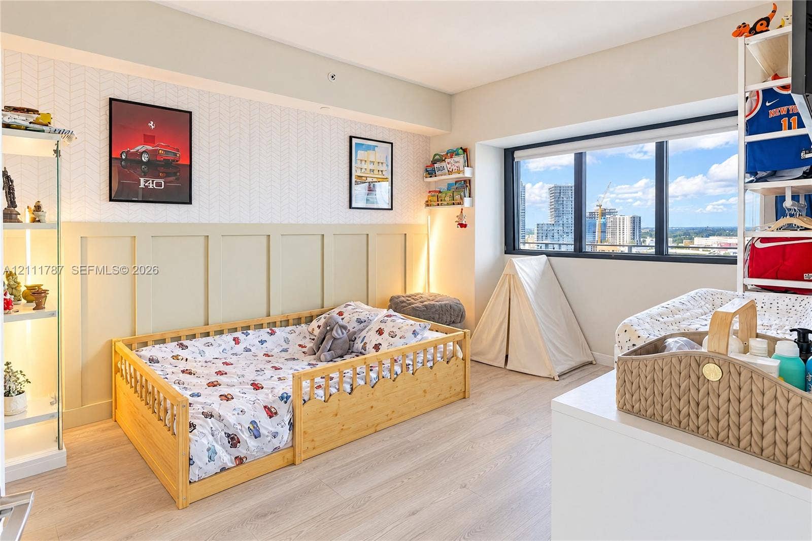 Room featuring large-format windows, wood-finish flooring, and decorative wall molding with a textured wallpaper finish