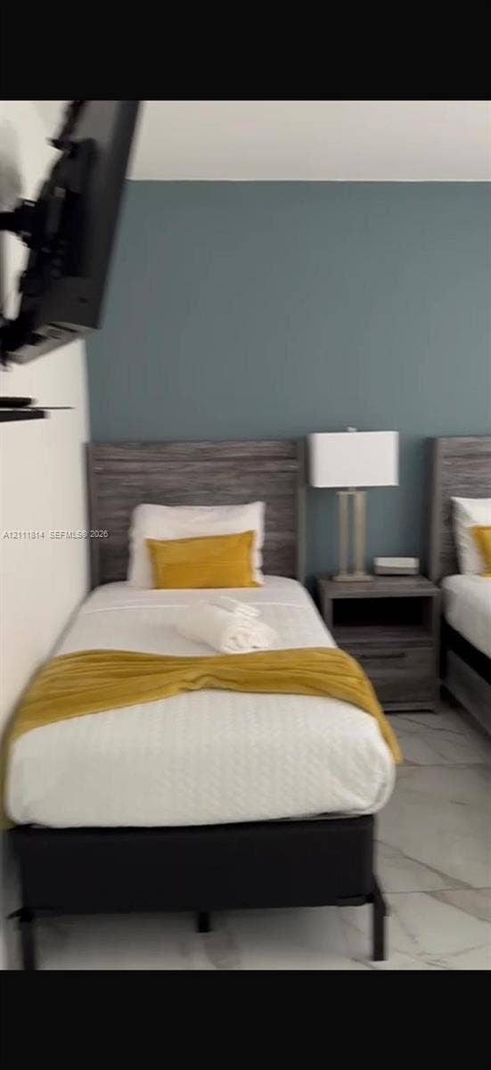 Accent wall painted in a muted blue tone, complemented by light-colored flooring with stone-patterned tile