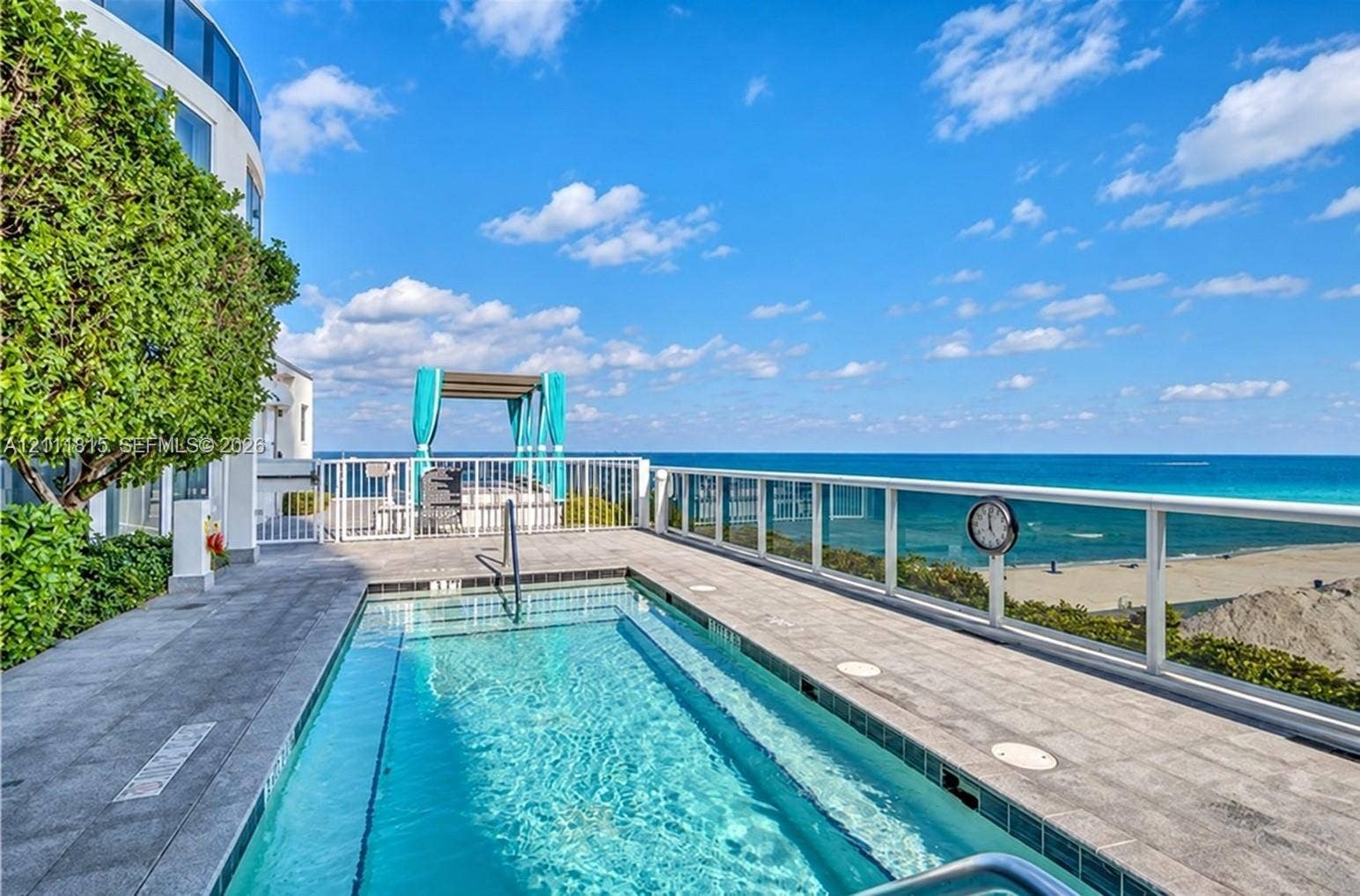 15811 Collins Avenue, #4102, Sunny Isles Beach, FL 33160 Curved, textured wall detailing, floor-to-ceiling windows, wood-finish flooring, and multi-light pendant illumination