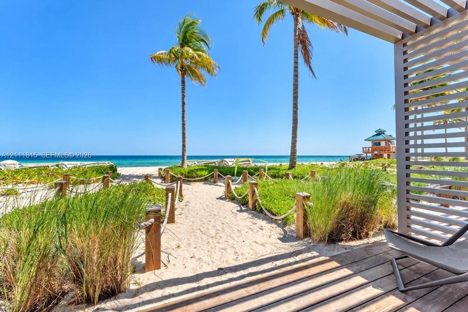 15811 Collins Avenue, #4102, Sunny Isles Beach, FL 33160 Covered wood deck with slatted privacy screen, sand path with rope perimeter, and coastal landscaping