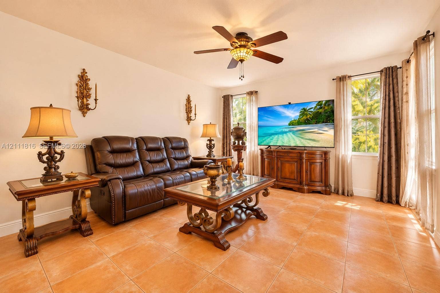 Ceramic tile flooring, ceiling fan with integrated lighting, and dual wall-mounted ornamental sconces