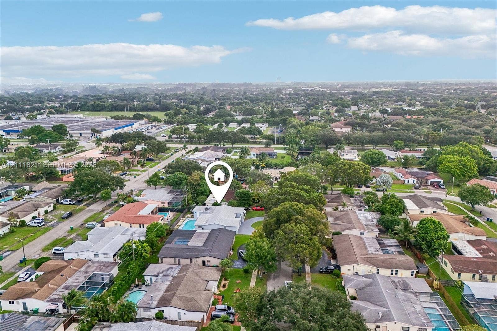 Aerial perspective of a property featuring an in-ground swimming pool and a paved driveway