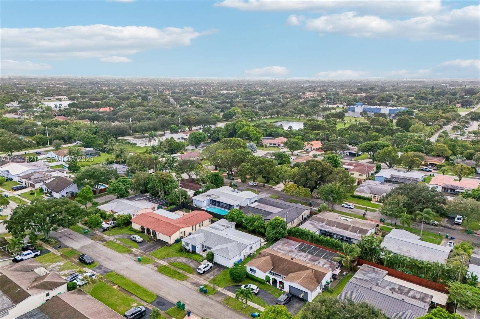Aerial perspective of residential neighborhood featuring mature trees, paved streets, and diverse housing styles
