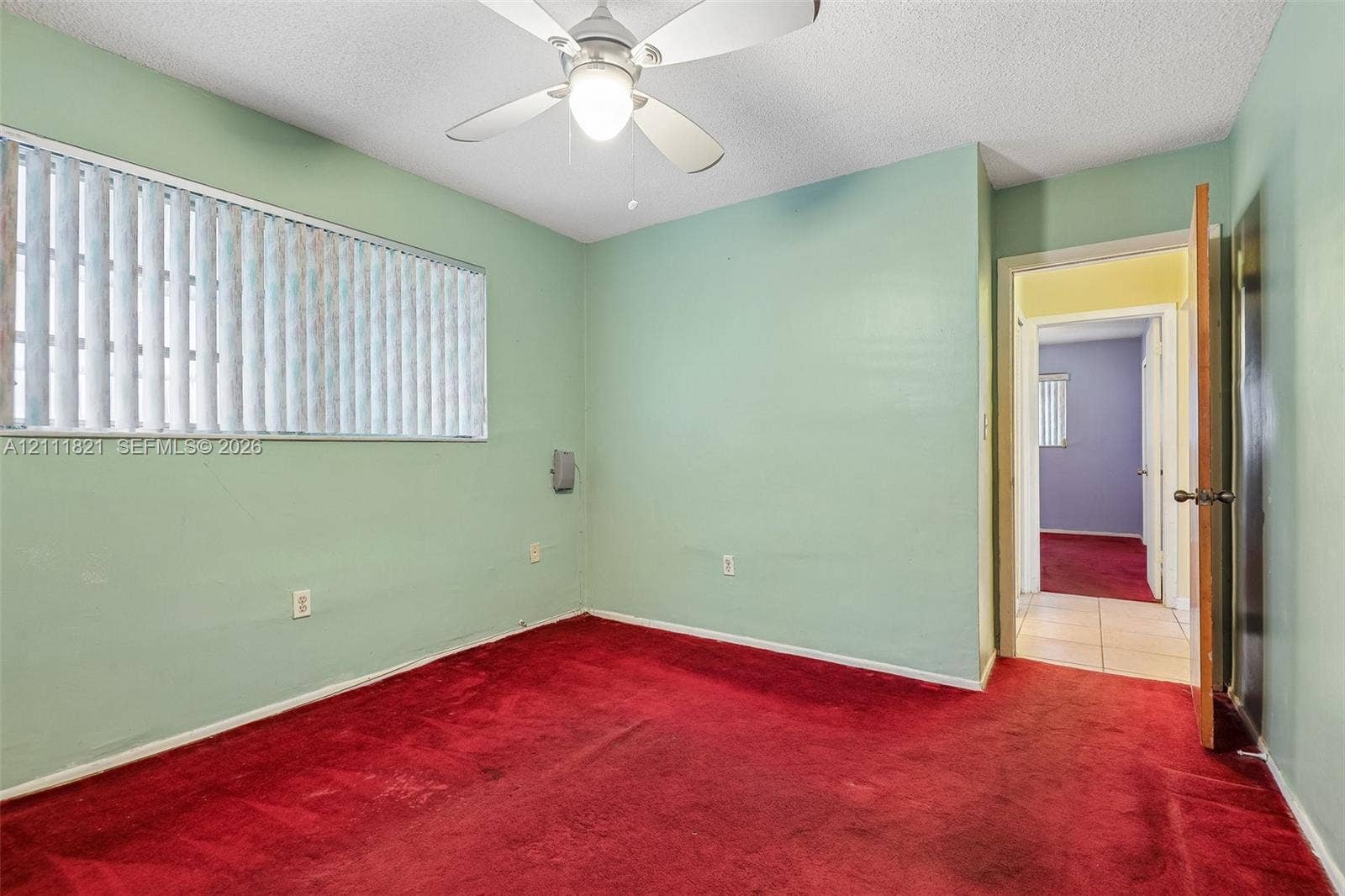 Room featuring wall-to-wall carpeting, a ceiling-mounted light fixture with fan, and horizontal window blinds
