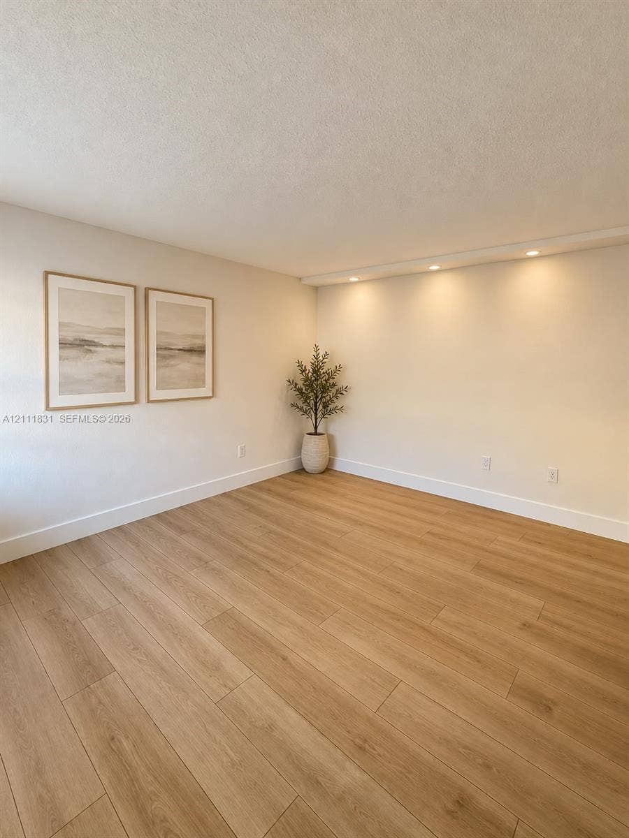1629 N River Drive, #103, Miami, FL 33125 Neutral-toned room featuring wood-finish flooring and recessed ceiling lighting