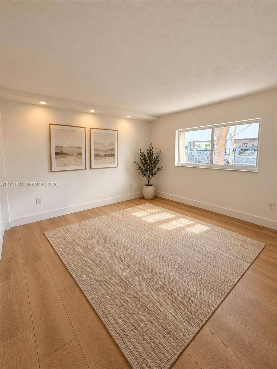 1629 N River Drive, #103, Miami, FL 33125 Bright room featuring wood-finish flooring, recessed lighting, and a large horizontal sliding window