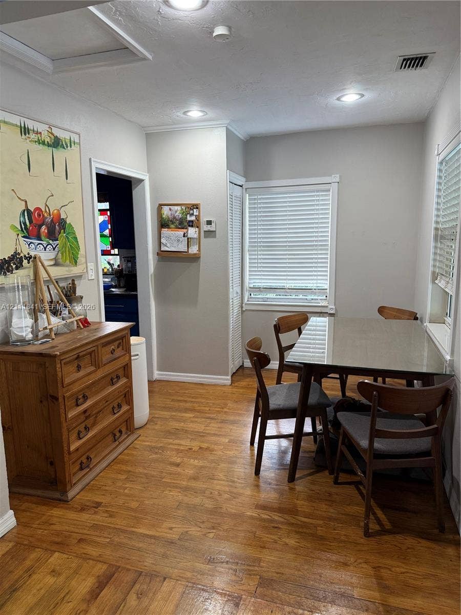 12015 NE 6th Avenue, Biscayne Park, FL 33161 Wood-finish flooring, recessed lighting, neutral wall paint, white louvered-door closet, and dual windows with horizontal blinds