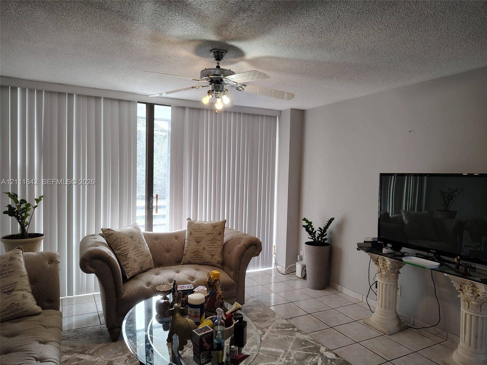 20400 W Country Club Drive, #303, Aventura, Aventura, FL 33180 Living area featuring tile flooring, ceiling fan with integrated lighting, and floor-to-ceiling vertical blinds
