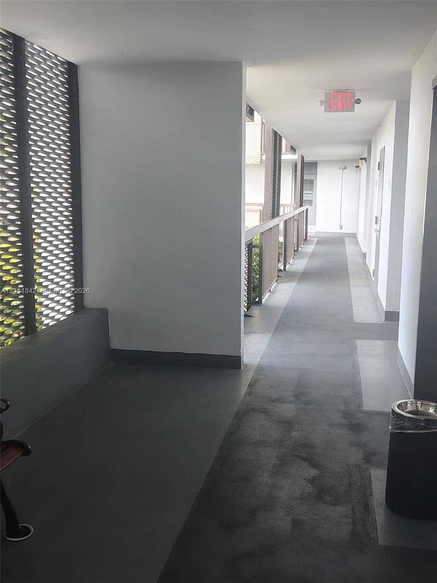 20400 W Country Club Drive, #303, Aventura, Aventura, FL 33180 Covered exterior corridor featuring painted concrete flooring and decorative metallic lattice privacy screening