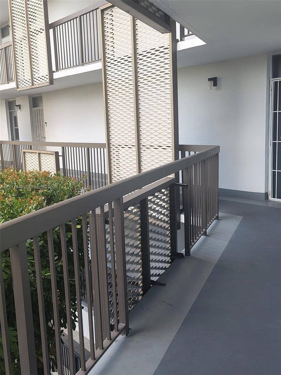 20400 W Country Club Drive, #303, Aventura, Aventura, FL 33180 Exterior walkway featuring a metal railing, geometric privacy screens, and integrated wall-mounted lighting