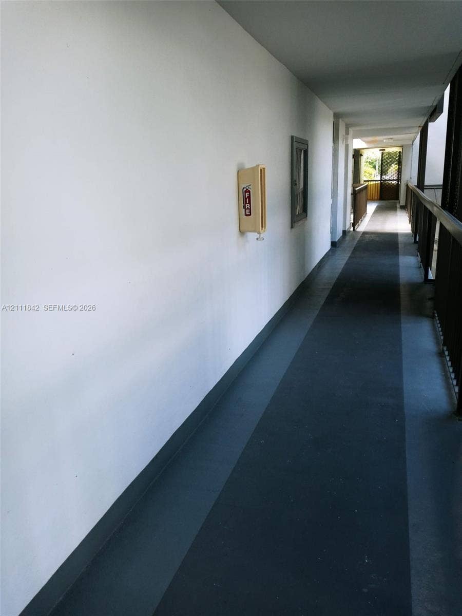 20400 W Country Club Drive, #303, Aventura, Aventura, FL 33180 Exterior corridor featuring smooth white walls, dark-toned flooring, and a metal railing