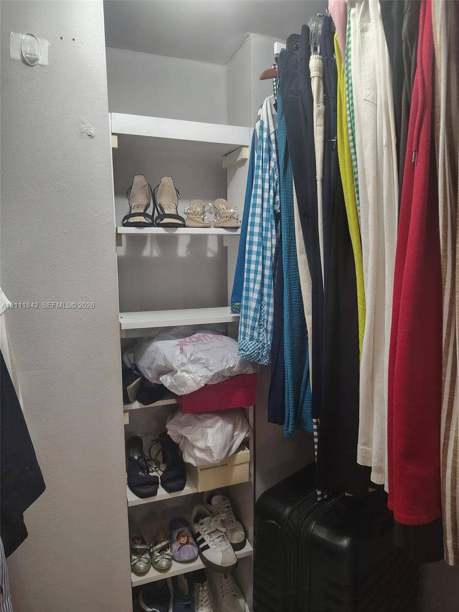 20400 W Country Club Drive, #303, Aventura, Aventura, FL 33180 Walk-in closet featuring white built-in vertical shelving and an integrated metal garment hanging rod
