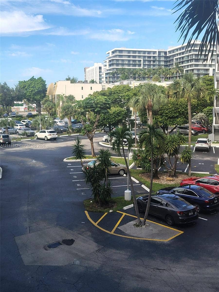 20400 W Country Club Drive, #303, Aventura, Aventura, FL 33180 Paved surface parking area featuring designated stalls and mature palm tree landscaping