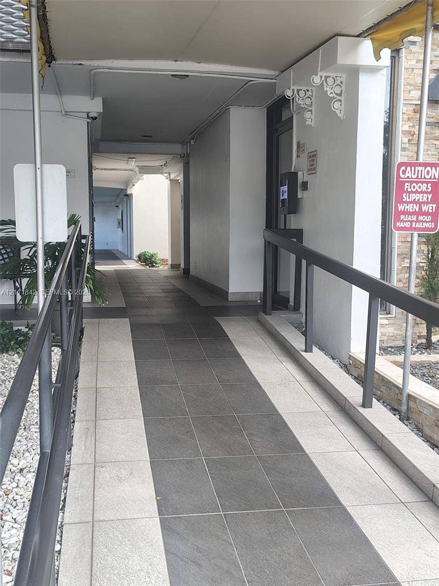 20400 W Country Club Drive, #303, Aventura, Aventura, FL 33180 Covered exterior walkway featuring dual-tone tile flooring and metal handrails