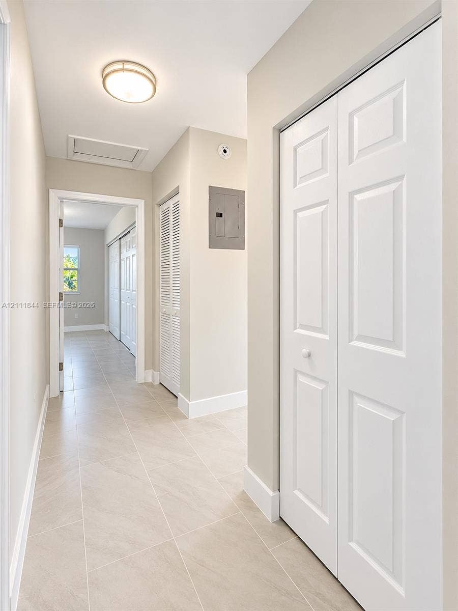 Neutral-toned tile flooring, white paneled closet doors, and recessed overhead lighting