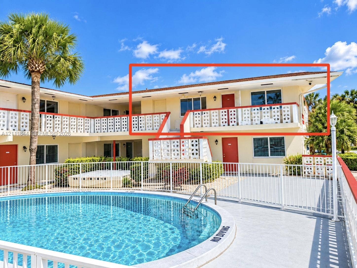 Second-story exterior featuring a private balcony, decorative breeze block railings, and sliding glass windows