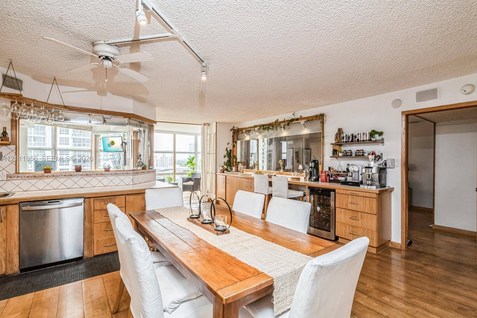 6423 Collins Avenue, #1602, Miami Beach, FL 33141 Kitchen featuring light-finish cabinetry, built-in wine refrigerator, stainless steel dishwasher, track lighting, and wood-finish flooring