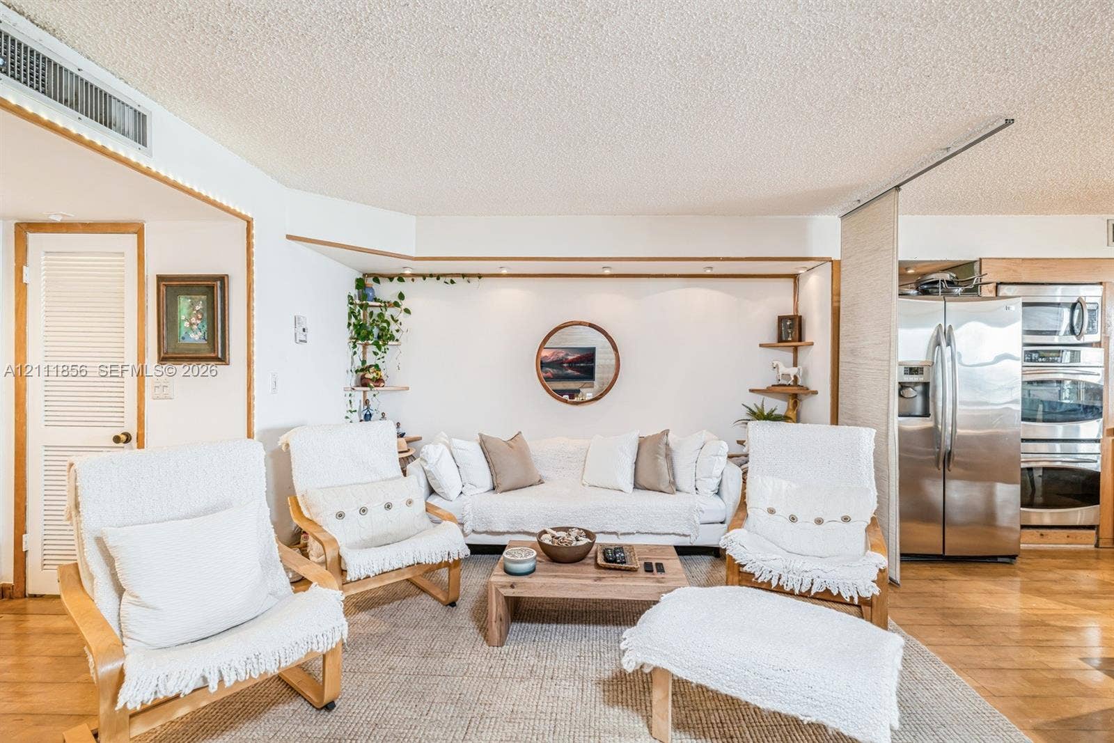 6423 Collins Avenue, #1602, Miami Beach, FL 33141 Open-concept interior featuring wood-finish flooring, recessed lighting, built-in shelving, a stainless steel double wall oven, and a stainless steel side-by-side refrigerator