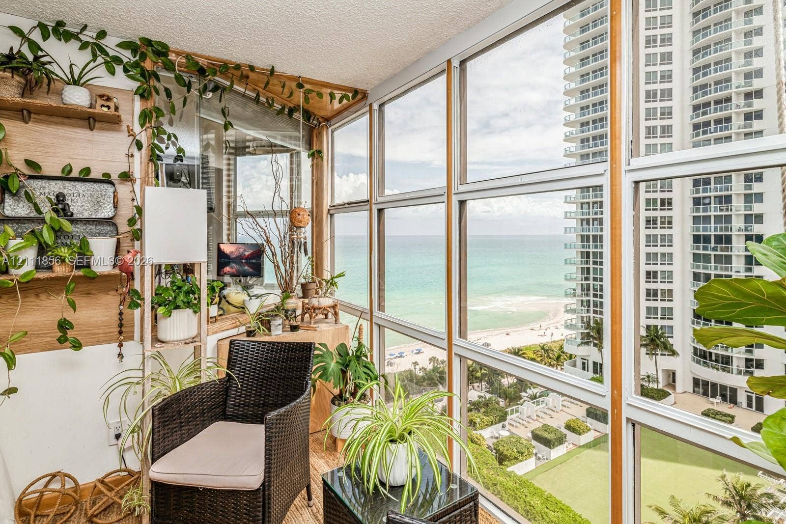 6423 Collins Avenue, #1602, Miami Beach, FL 33141 Enclosed sunroom featuring floor-to-ceiling windows, wood-finish wall paneling, and wood-finish flooring