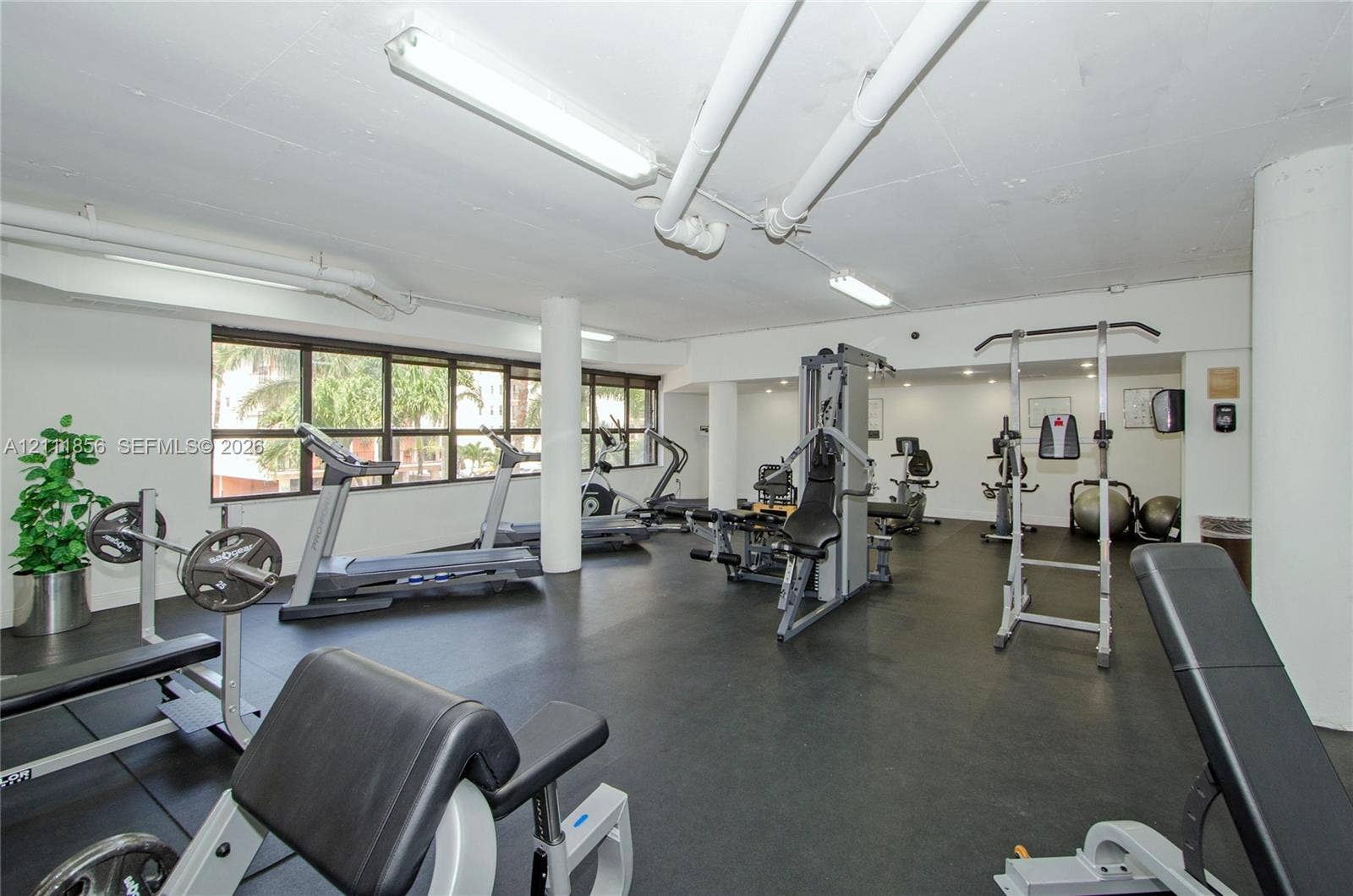 6423 Collins Avenue, #1602, Miami Beach, FL 33141 Fitness center featuring rubber flooring, expansive windows, exposed overhead infrastructure, and structural columns