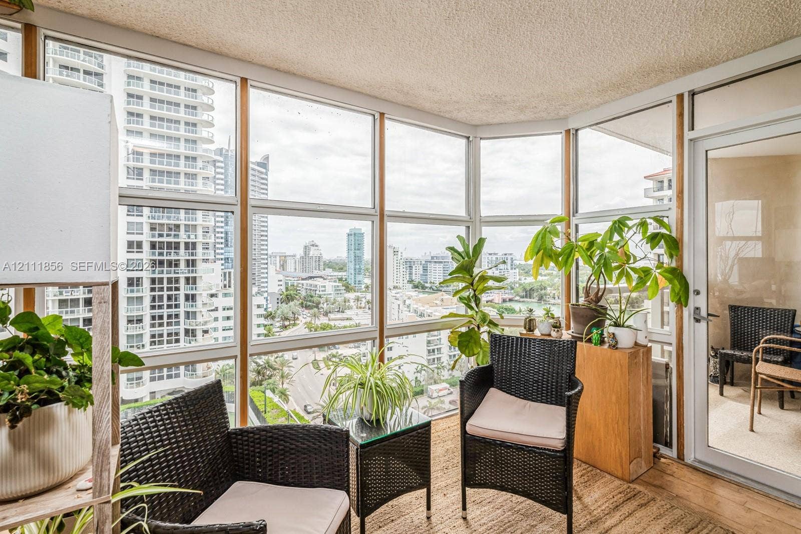 6423 Collins Avenue, #1602, Miami Beach, FL 33141 Enclosed balcony featuring floor-to-ceiling windows with panoramic urban exposure and a glass-paneled door