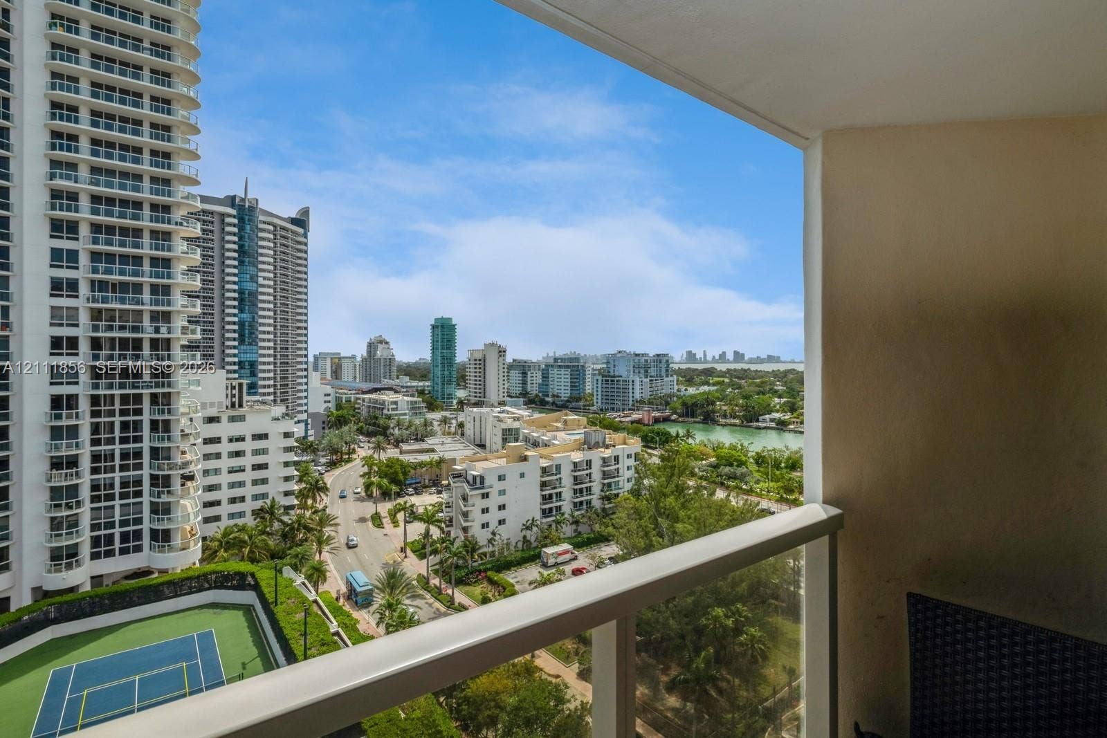 6423 Collins Avenue, #1602, Miami Beach, FL 33141 Private balcony featuring a glass and metal railing, overlooking the urban skyline, waterway, and tennis court
