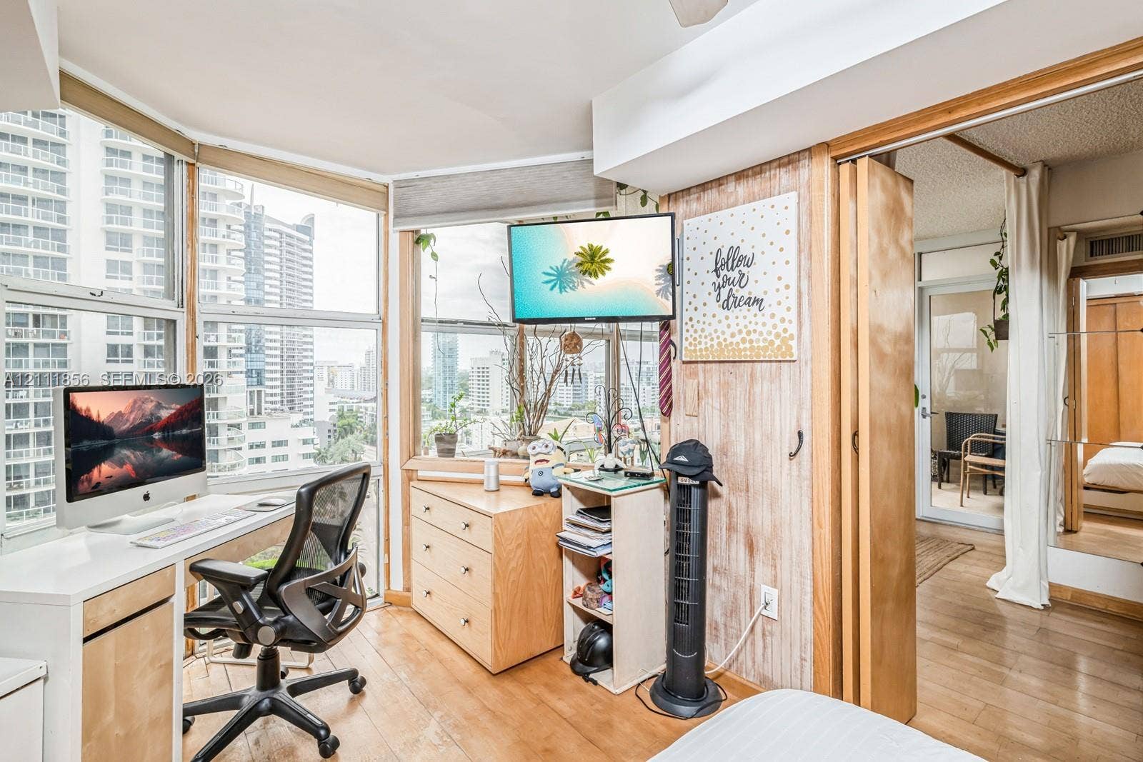 6423 Collins Avenue, #1602, Miami Beach, FL 33141 Floor-to-ceiling windows with urban exposure, wood-finish flooring, and wood-paneled accent wall