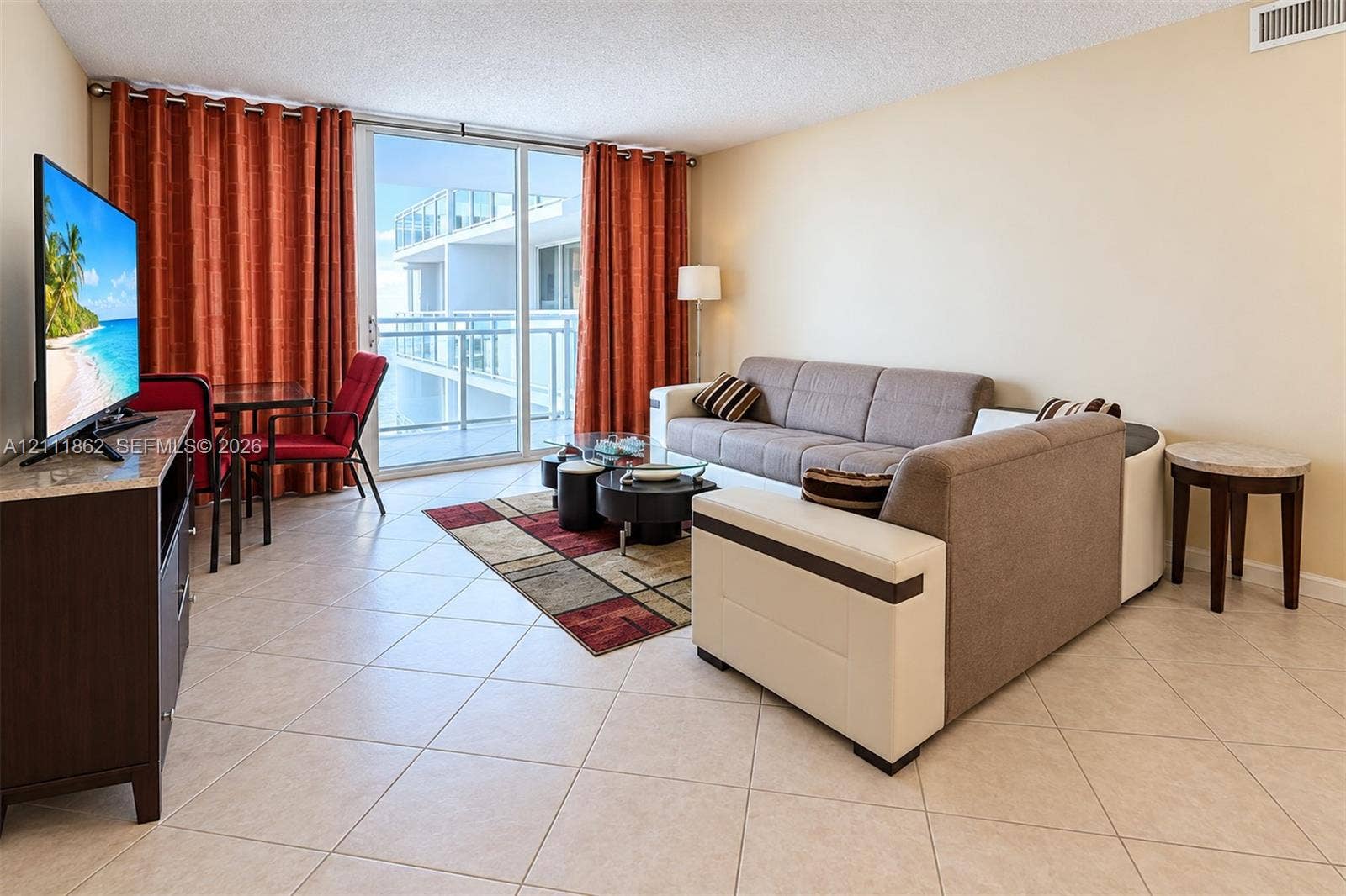 2030 S Ocean Drive, #2004, Hallandale Beach, FL 33009 Living area featuring large-format diagonal tile flooring, floor-to-ceiling glass sliding doors, and a private balcony with metal railing