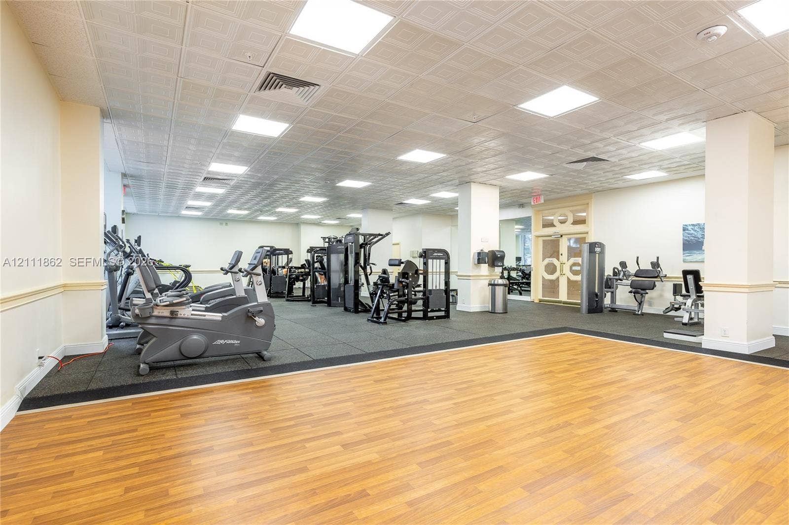 2030 S Ocean Drive, #2004, Hallandale Beach, FL 33009 Spacious fitness center featuring wood-finish flooring, a rubberized exercise surface, recessed ceiling lighting, a decorative coffered ceiling, and glass-paneled double doors