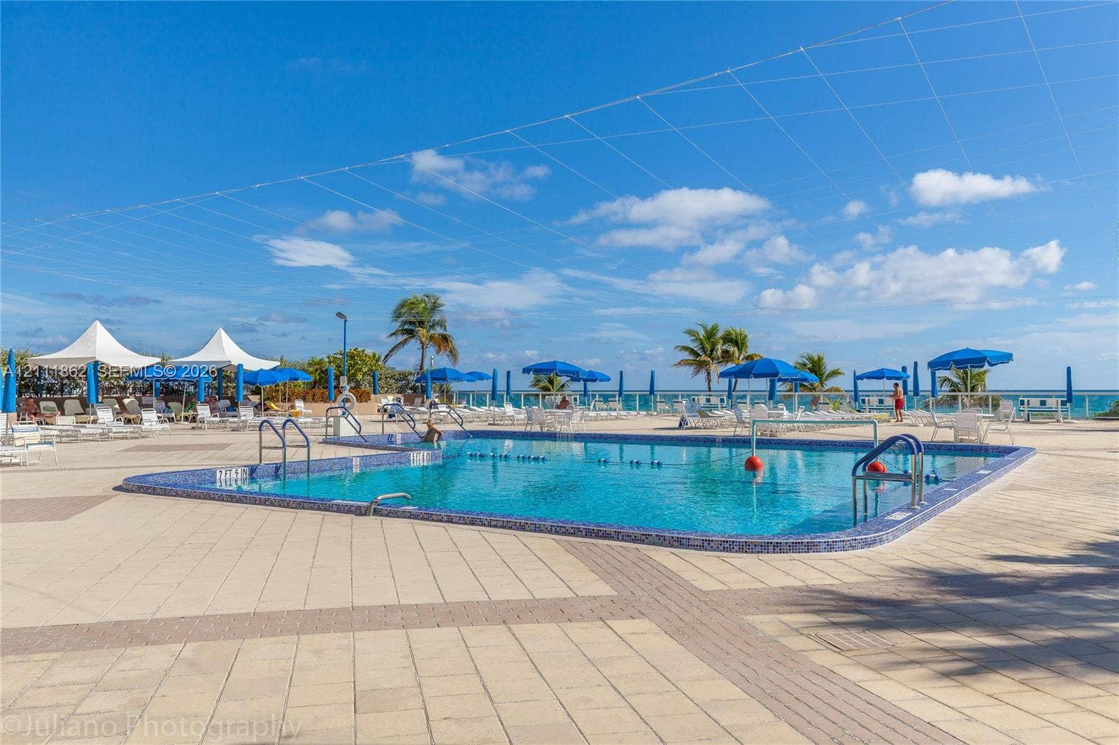 2030 S Ocean Drive, #2004, Hallandale Beach, FL 33009 In-ground swimming pool with mosaic tile surround, expansive stone-paver deck, and perimeter glass fencing