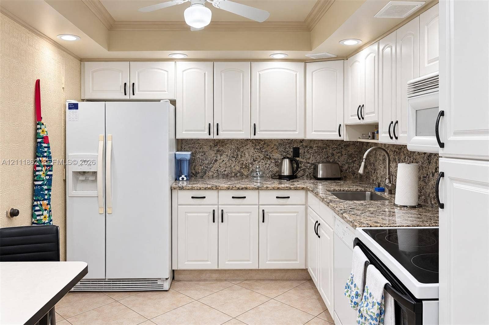 2030 S Ocean Drive, #2004, Hallandale Beach, FL 33009 Kitchen featuring white raised-panel cabinetry, stone-patterned countertops, a stainless steel undermount sink with a gooseneck faucet, tile flooring, and recessed ceiling lighting