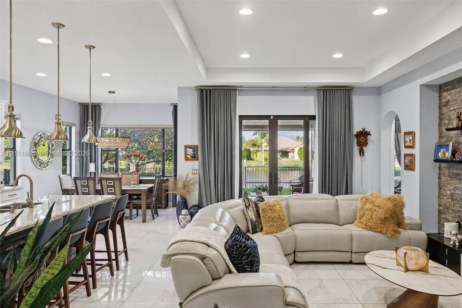 1034 SW 113th Avenue, Pembroke Pines, FL 33025 Broad view of open-concept floor plan featuring polished tile flooring & tray ceilings with recessed lighting.