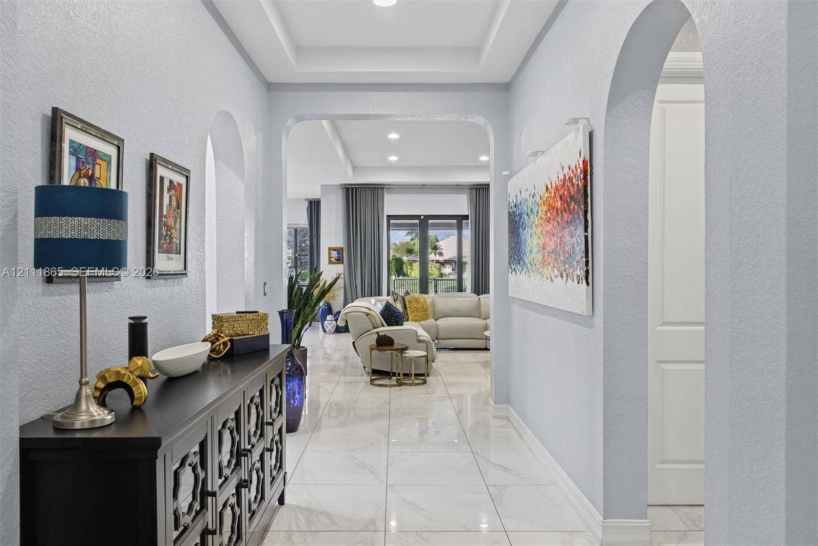 1034 SW 113th Avenue, Pembroke Pines, FL 33025 Entryway featuring large-format tile flooring, recessed tray ceiling, and prominent arched architectural openings