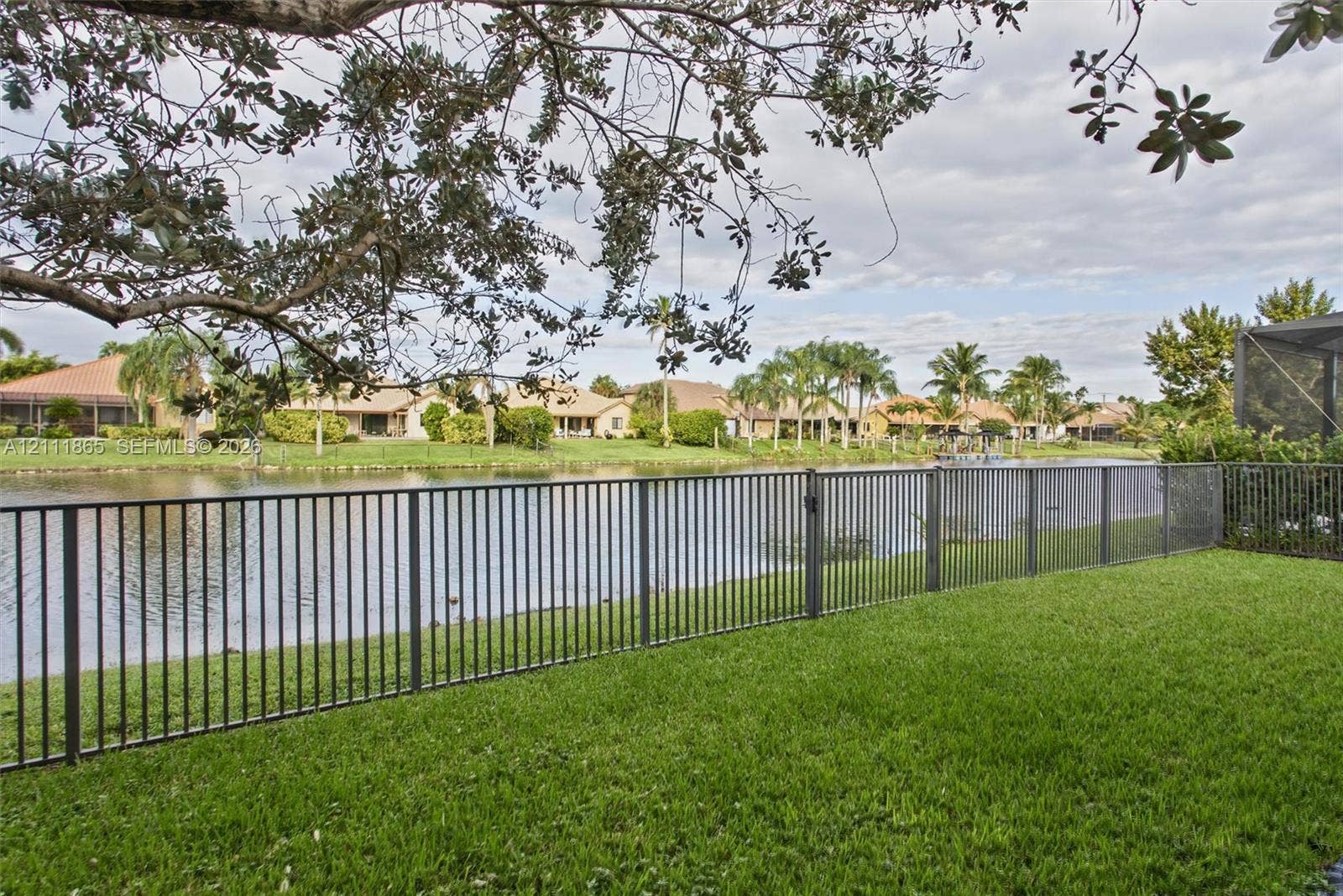 1034 SW 113th Avenue, Pembroke Pines, FL 33025 Fenced backyard featuring a manicured lawn and direct water frontage