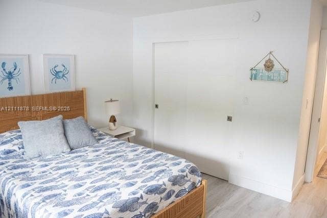 201 Galen Drive, #110, Key Biscayne, FL 33149 Interior space featuring neutral wall paint, wood-finish flooring, and sliding-panel closet doors