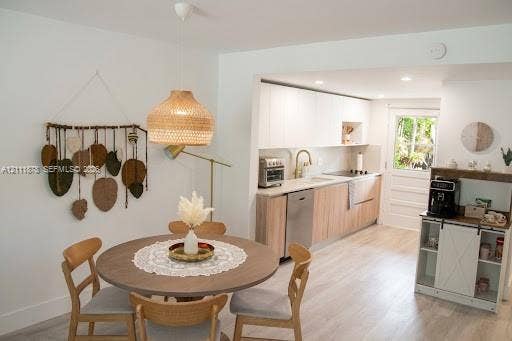201 Galen Drive, #110, Key Biscayne, FL 33149 Kitchen featuring two-tone cabinetry with wood-finish lower panels, stone-surface countertops, stainless steel dishwasher, brass-tone faucet, and wood-finish flooring
