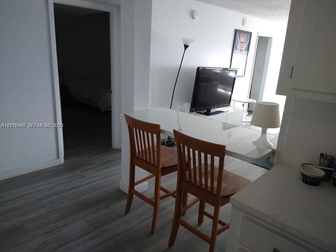 Interior featuring wood-finish flooring and a white, built-in breakfast bar