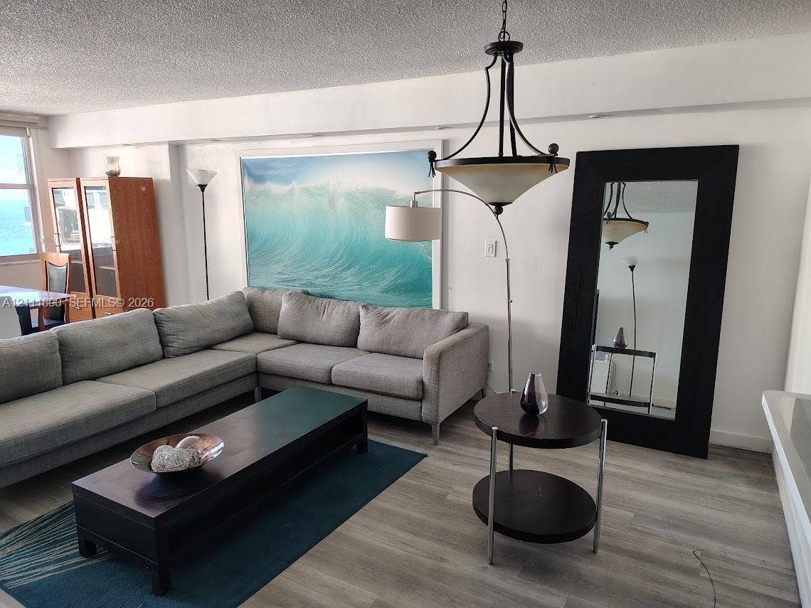 Wood-finish flooring, metal multi-arm chandelier, and neutral wall tones
