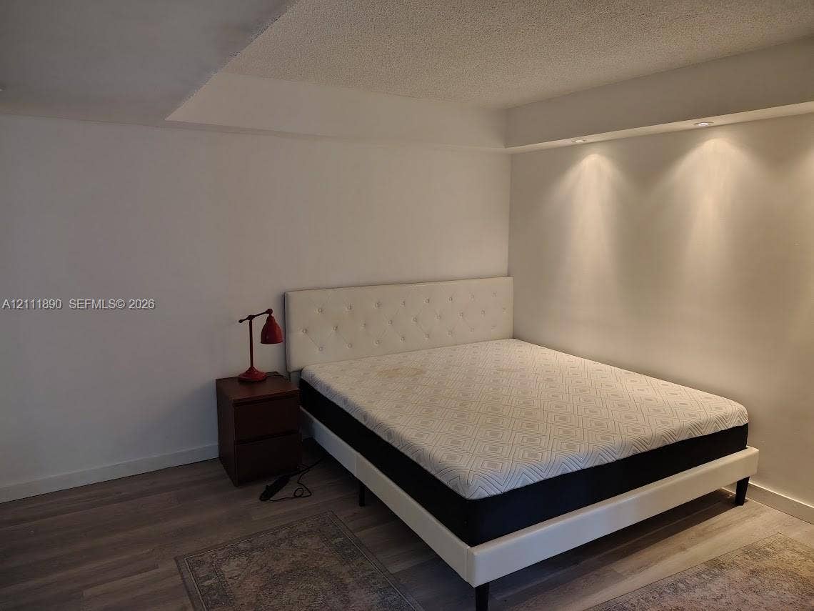 Neutral walls, wood-finish flooring, and recessed ceiling lighting