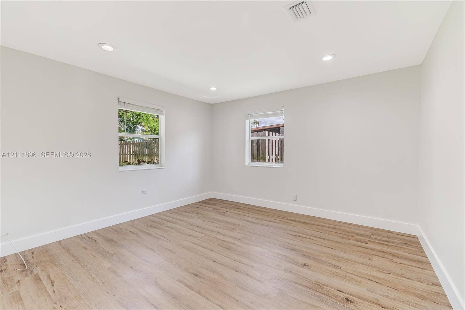 Interior room featuring wood-finish flooring, recessed lighting, and dual windows