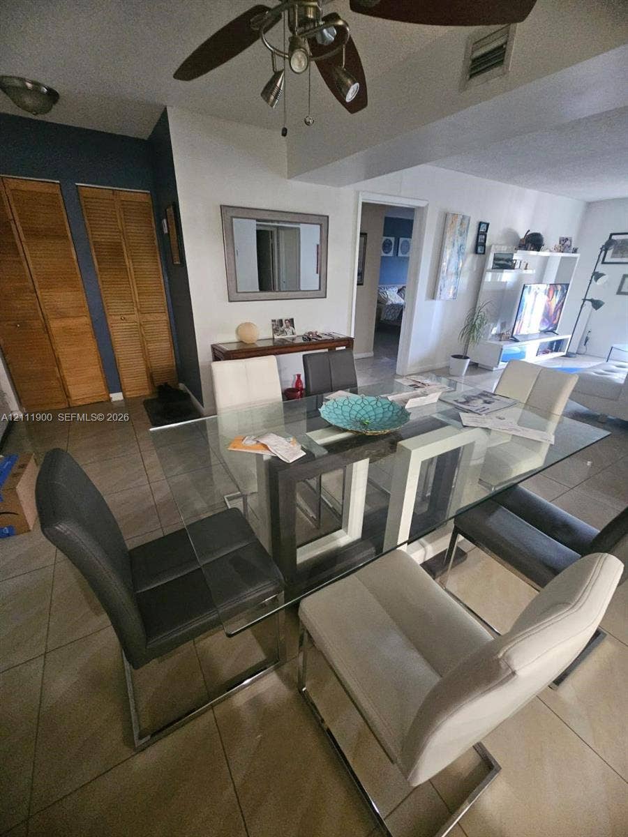 711 N Pine Island Road, #402, Plantation, Plantation, FL 33324 Ceramic tile flooring, bi-fold louvered closet doors, and multi-bulb ceiling fan fixture