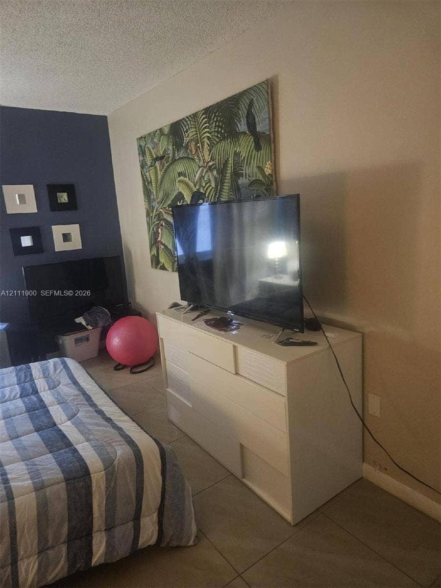 711 N Pine Island Road, #402, Plantation, Plantation, FL 33324 Room featuring large-format ceramic tile flooring and an accent wall finished in a deep blue tone