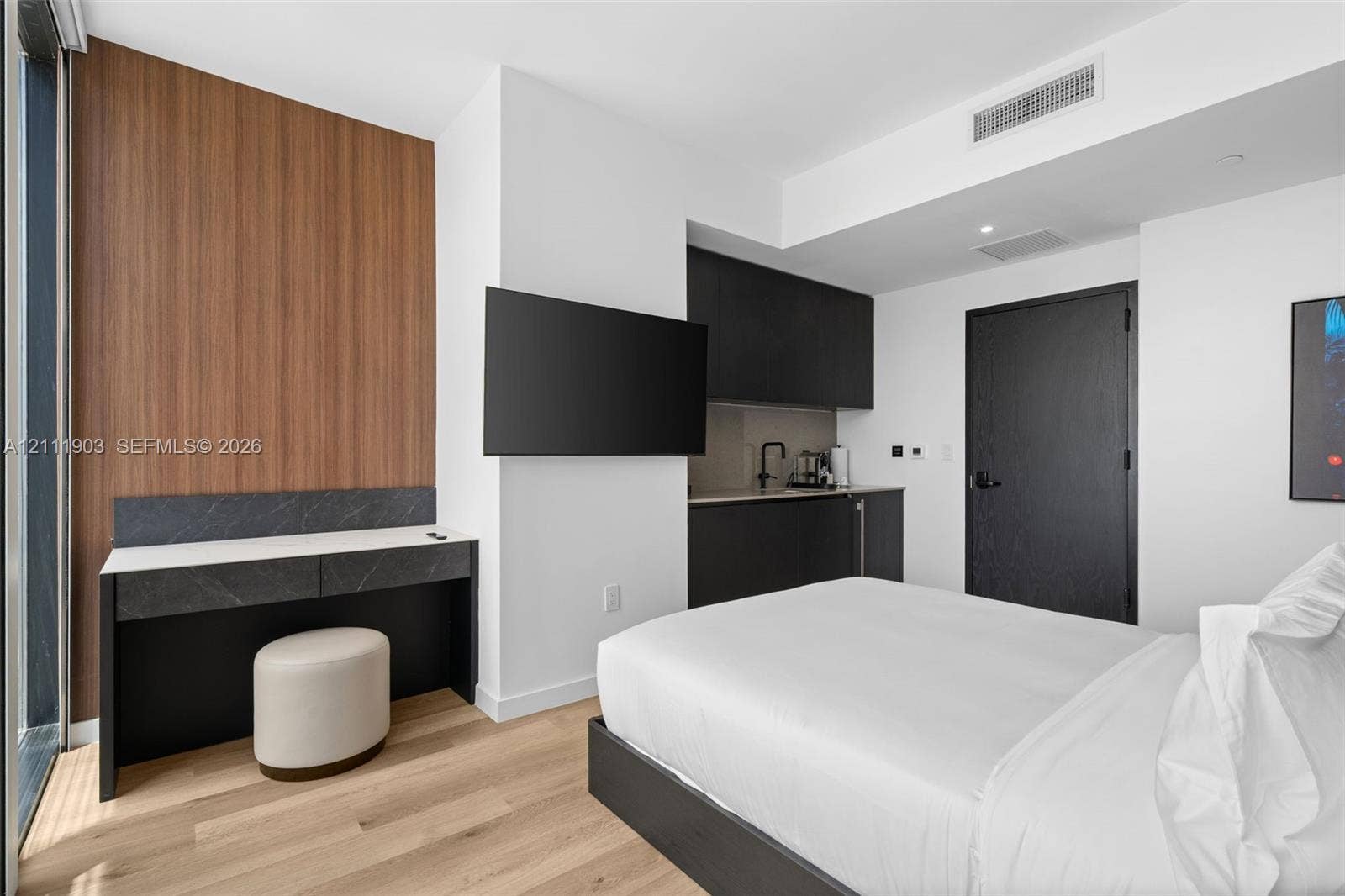 20 NE 11th Street, #4308, Miami, FL 33132 Built-in desk with stone-finish surface, wood-finish flooring, matte black cabinetry, and wood-paneled accent wall
