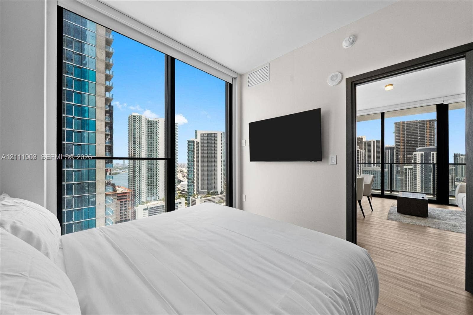20 NE 11th Street, #4308, Miami, FL 33132 Floor-to-ceiling windows, wood-finish flooring, and urban skyline backdrop